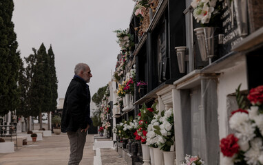 Adult man mourning his family in cemetery. Almeria, Spain