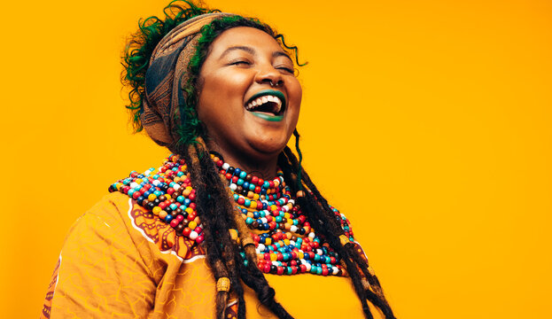 Cheerful ethnic woman laughing while wearing African traditional clothing