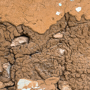 The background is textured stone clay with straw. Adobe.