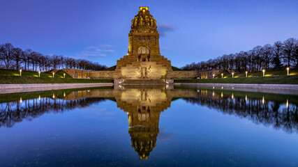 Monument to the Battle of the Nations at sunrise with a lake in the foreground