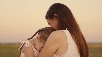 young woman hugs a small upset child, a kid in the family is mother, girl daughter complains to her...