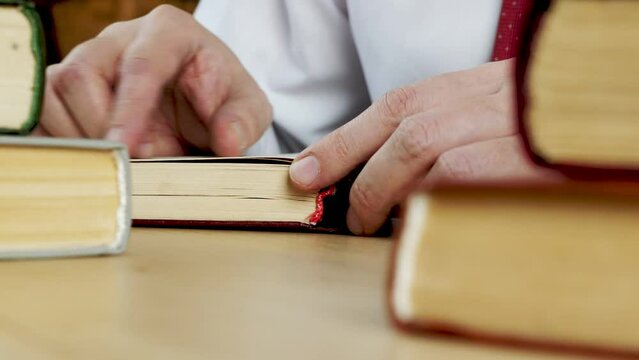 Close-up of hands opening a book. Knowledge and study.