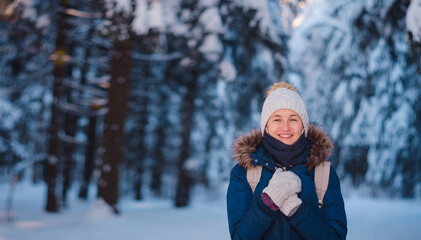 Fototapeta na wymiar Happy Asian woman walking in winter snow forest. Cold weather hat and warm coat. idea and concept of healthy active lifestyle and good mood in any weather