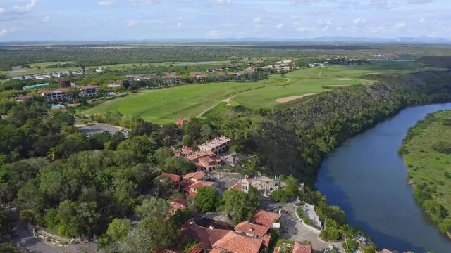 Aerial flyover Casa de Campo Village with Golf Resort beside Chavon River on Dominican Republic Island during summer
