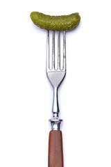 Tasty canned Whole green cornichon on a fork isolated on a white background