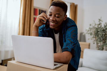 Happy man moves into newly bought house, buys furniture online, uses modern technology, guy surfs...