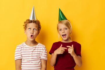 picture of positive boy and girl holiday fun with caps on your head isolated background