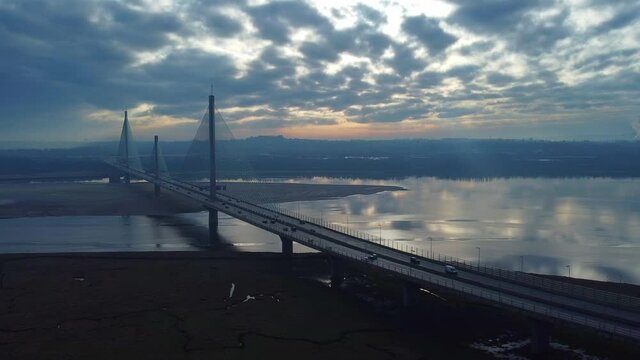 Mersey Gateway cable suspension bridge with sunrise reflections in river landmark aerial orbit right view