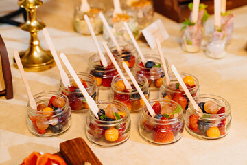 Catering. convenient portioned serving of fruit salad in small jars. beautiful original table setting for banquet.