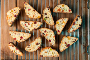 Homemade cookies with nuts, cranberries, cherries and candied fruits on wood background