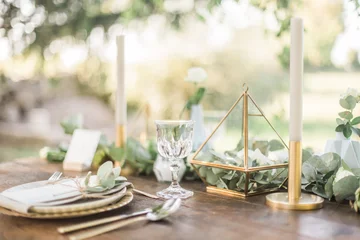 Foto op Canvas Luxury wedding reception dinning table setup with eucalyptus branches and gold geometric decoration on a rustic wooden table © Andrej