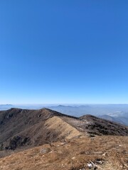 한국 소백산 정상과 능선, 억새 풍경, 등산하는 여자 /  The summit of Sobaeksan Mountain in Korea, ridges, silver grass scenery, and a woman hiking 