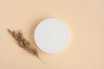 Podium for cosmetic product presentation. Abstract minimal geometrical form. Cylinder podium with dry pampas grass, soft shadow. Scene to show products. Showcase, display case. Flat lay, top view