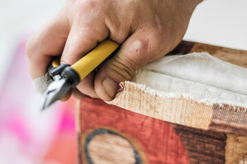The workflow of furniture restoration. Men's hands remove the old upholstery. Selective Focus.