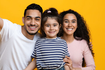 Cheerful Young Middle Eastern Parents And Little Daughter Taking Selfie Together