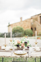 Romantic dinning table at villa backyard in Tuscany, decorated with flowers and candles.