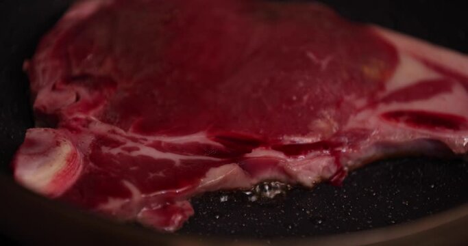A timelapse of grilling T born stake meat on the pan in the kitchen close up
