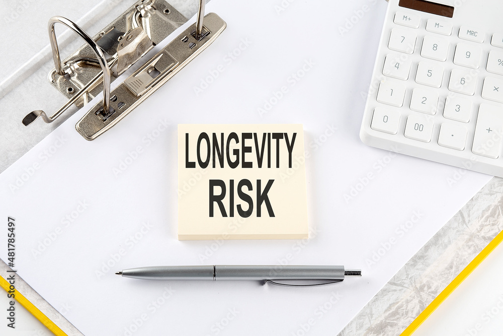 Poster longevity risk - business concept, message on the sticker on folder background with calculator