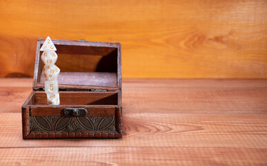 Set role playing white dices stand top each other in open storage box on gaming table made wood: role-playing games with place for text