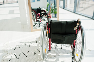 Empty wheelchair at home. Wheel chair indoor in mirror.