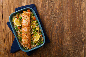 Asian dish. Fried salmon with rice and vegetables. Sprinkled with sesame seeds.