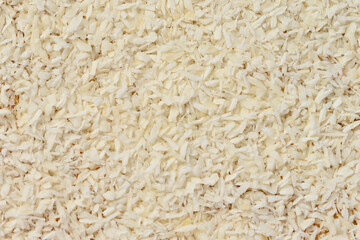 Tasty fresh coconut flakes background, top view, texture