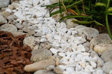 the use of natural materials in landscape design. Pine bark, white stones and pebbles as decoration...