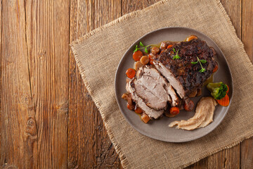 Whole roasted pork neck, stewed in wine with vegetables.