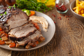 Fototapeta na wymiar Whole roasted pork neck, stewed in wine with vegetables.