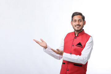 young indian man in traditional wear and showing direction on white background.