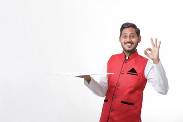 young indian man in traditional wear and giving expression on white background.