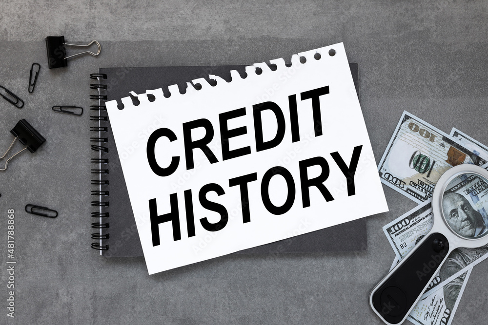 Poster credit history on a gray working table lies a gray notepad with text.