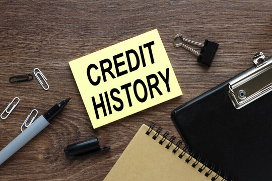 Credit history. wood table with yellow sticker