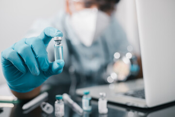A doctor or scientist in the COVID-19 medical vaccine research and development laboratory holds a...