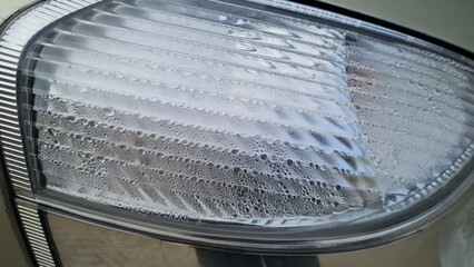 Foggy headlight with condensation in a modern car