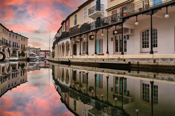 Reflection of the dramatic sunset sky on the canals of the Port Grimaud in Saint Tropez, French Riviera.