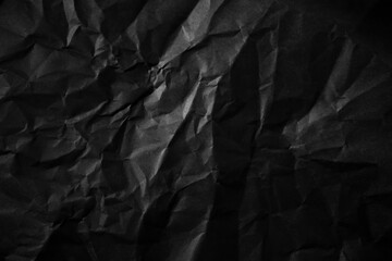 Textured crumpled black paper background.