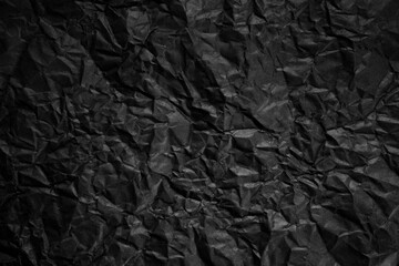 Textured crumpled black paper background.