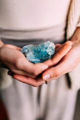 Woman holding celestine geode indoors. Spiritual unrecognizable woman with a precious mineral on...