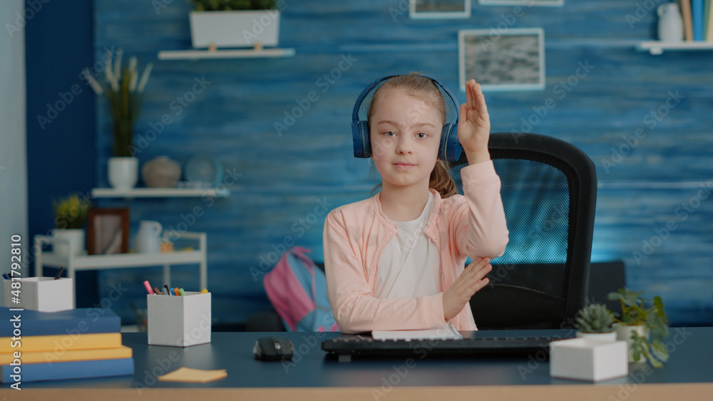 Poster pov of little girl using video call for online class lessons. child wearing headphones and listening