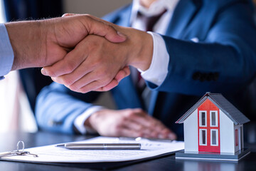 Real estate brokers are shaking hands to congratulate buyers after agreeing to insure and buy a house project. , Home Insurance Ideas home and land mortgage
