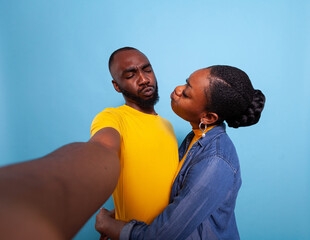 People in love doing kissy face at each other and taking pictures on camera. Joyful boyfriend and girlfriend enjoying sweet moment, expressing romantic feelings and love. Partners hugging.