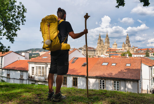 Pilgrim on the Camino de Santiago (St James way) contemplating the Cathedral of Santiago de Compostela on his arrival from the Camino Frances