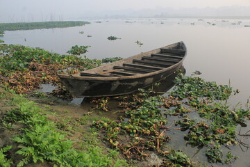 Obraz premium A broken boat in the riverside in a winter morning