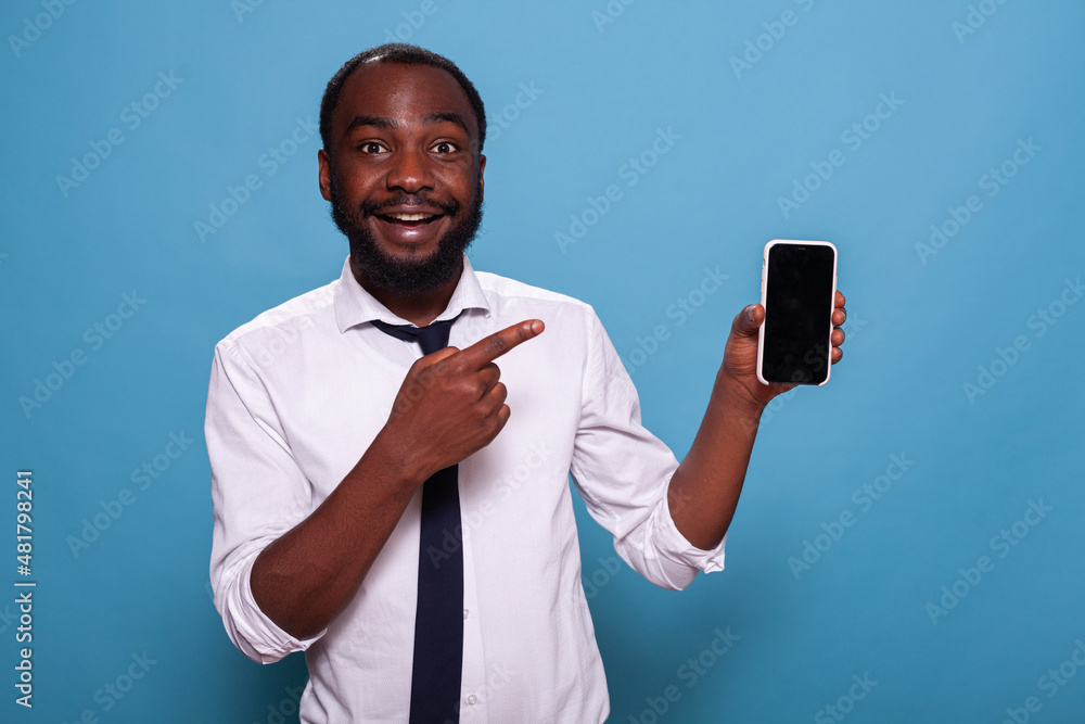 Poster enthusiastic happy person pointing at smartphone blank screen showing mobile feature of mobile game 