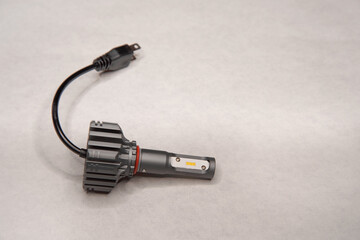 Modern LED headlight bulb for cars on a light gray background