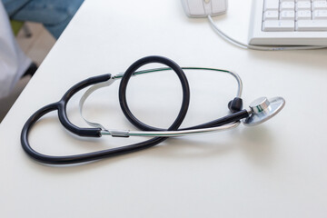 The stethoscope is lying on a white table in the medical office.