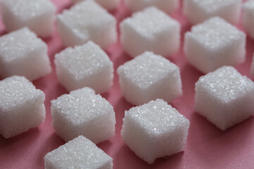 Sugar cubes on pink background