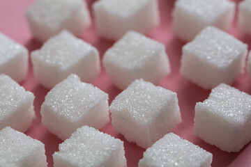 Sugar cubes on pink background