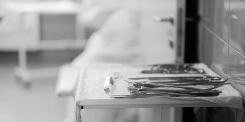 Sterile surgical instruments on the table in the hospital. Selective focus. Black and white photo....